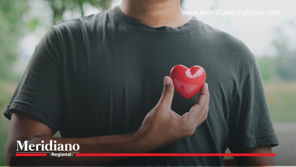 E.S.E. Norte 2 | Autocuidado y salud emocional desde el corazón - Meridiano Regional Persona sostiene un corazón rojo sobre su pecho, simbolizando el autocuidado y la importancia de atender la salud mental y emocional en la vida cotidiana. Imagen representativa de las campañas lideradas por la E.S.E. Norte 2 en el Cauca.