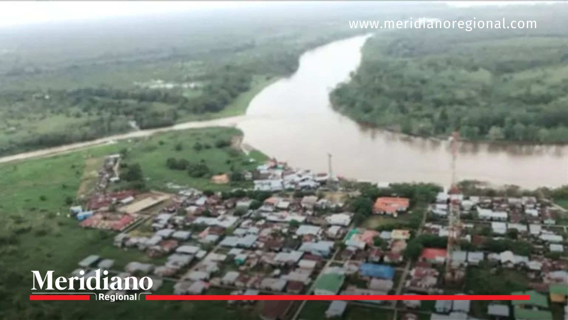 Vista aérea de municipio inundado por lluvias en Chocó, con río desbordado y casas en riesgo