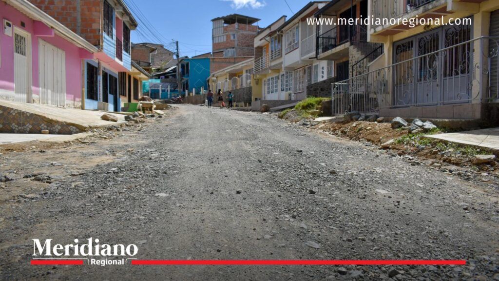 Vista de la Carrera 21A en el barrio Panamericano de Timbío, Cauca, con la vía destapada y viviendas a ambos lados, después de las obras de optimización del alcantarillado sanitario. Al fondo se observan varias personas caminando.