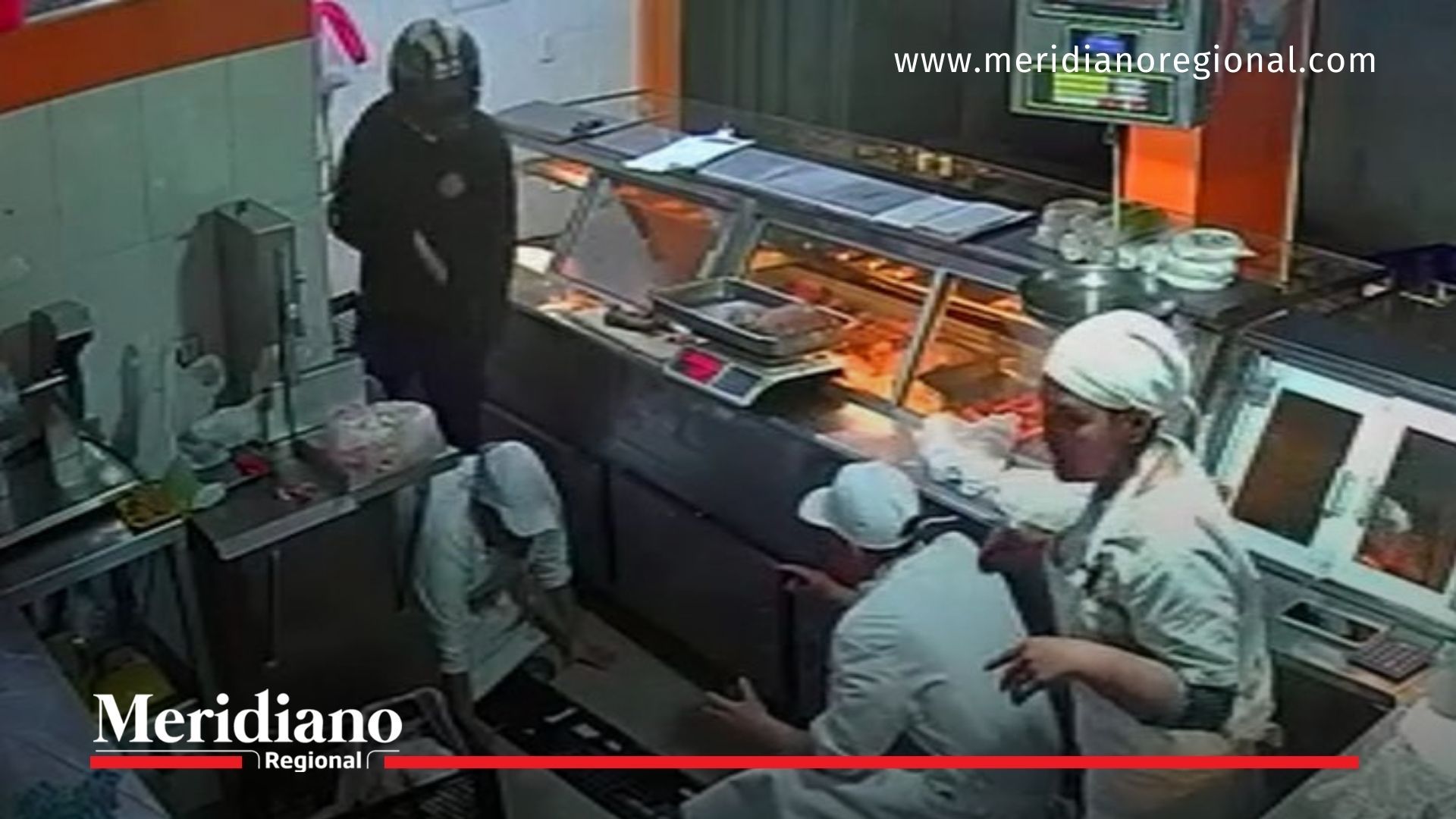 Momento en que un delincuente armado somete a trabajadores de una carnicería en Pasto.
