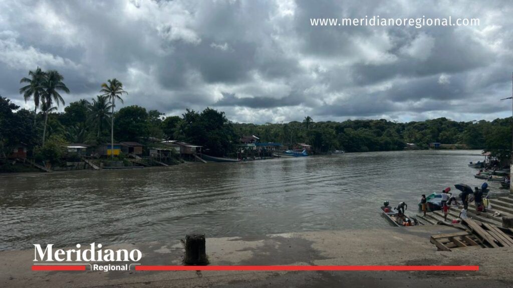 Puerto fluvial de Timbiquí, punto de llegada al municipio - Meridiano Regional Puerto fluvial de Timbiquí, Cauca, con embarcaciones pequeñas y habitantes realizando actividades de llegada y salida sobre el río.