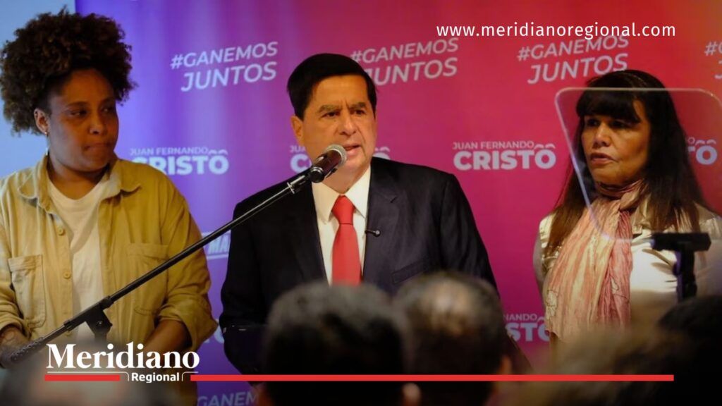 Juan Fernando Cristo presenta su candidatura presidencial en un evento público con asistentes y equipo de campaña.