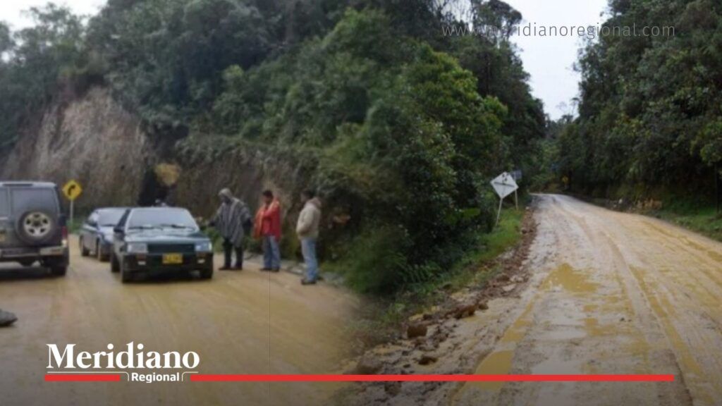 Vía Popayán Isnos con vehículos detenidos y carretera en mal estado en zona rural.