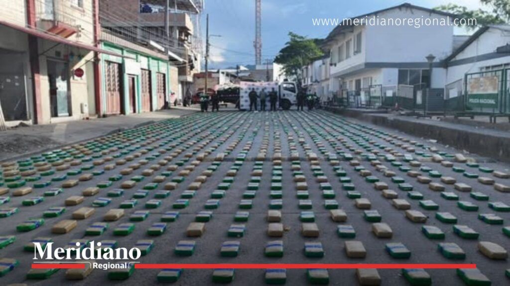 Droga incautada en operativo del corredor Popayán Isnos con paquetes de marihuana y capturados al fondo.