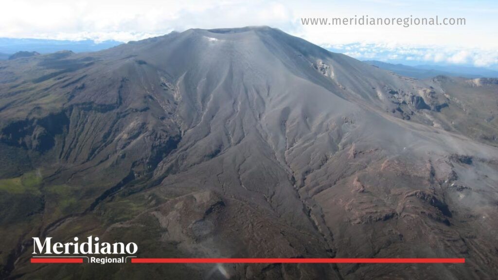 Actividad del volcán Puracé y emisión de gases - Meridiano Regional Vista aérea del volcán Puracé mostrando su cráter y laderas con emisiones de gases y material volcánico reciente.