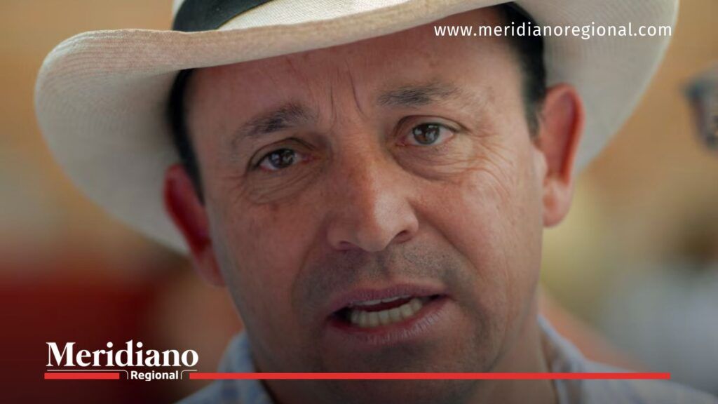 Primer plano de un hombre con sombrero claro mirando hacia la cámara.
