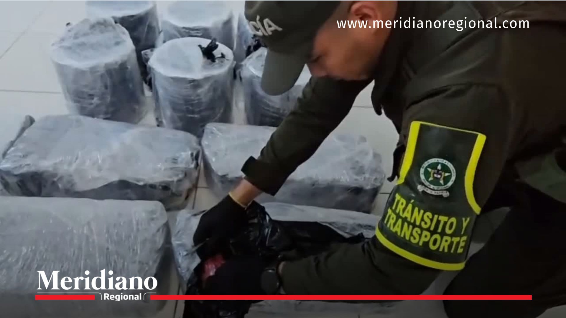 Policías de la Seccional de Tránsito y Transporte inspeccionan los paquetes donde fueron hallados los explosivos incautados en la vía Panamericana, en el sector de El Estrecho, Cauca.