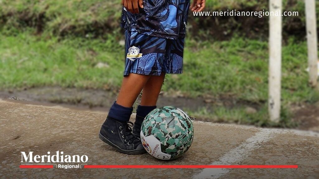 niño de la Escuela Soñadores FC estrenando balón durante la entrega kits deportivos en el asentamiento Gustavo Restrepo