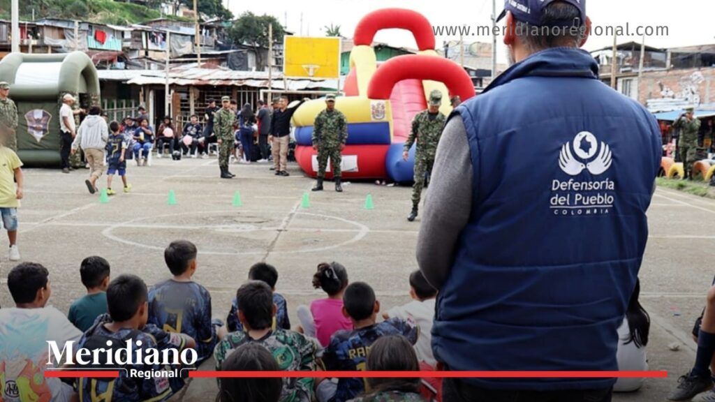 funcionario de la Defensoría del Pueblo en evento de entrega kits deportivos junto a niños de Soñadores FC en el asentamiento Gustavo Restrepo