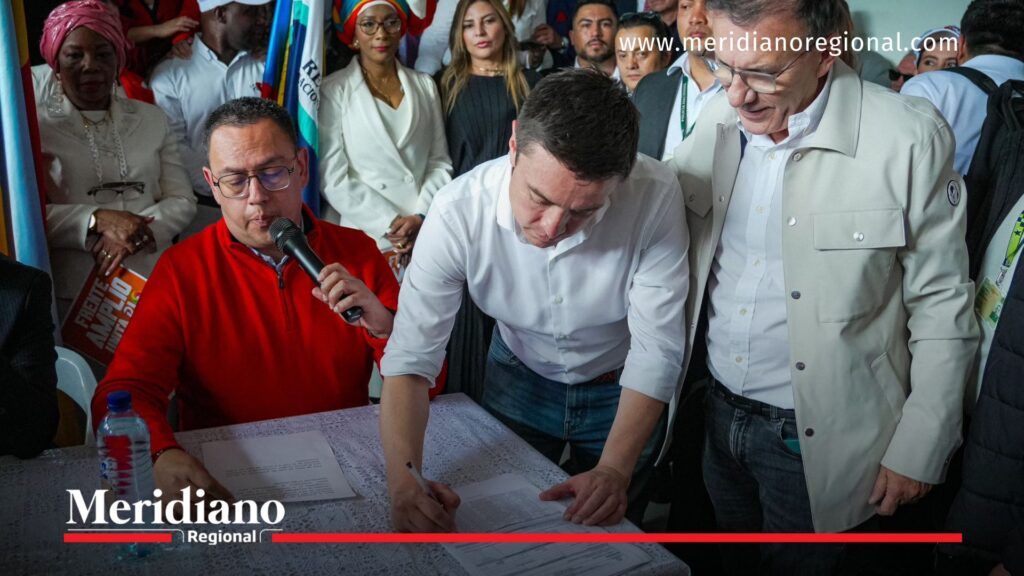 Firma de la lista del Frente Amplio presentada por Roy Barreras - Meridiano Regional Personas realizando la firma del documento oficial de inscripción de la lista del Frente Amplio Unitario, rodeadas de acompañantes y material institucional.
