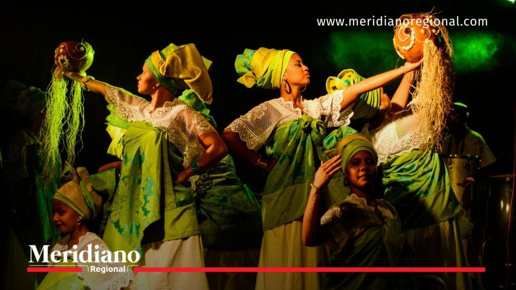 Colectivo artístico afrocolombiano en una puesta en escena con vestuarios verdes, ilustrando la convocatoria del Consejo de Áreas Artísticas – Teatro y Circo del Cauca.