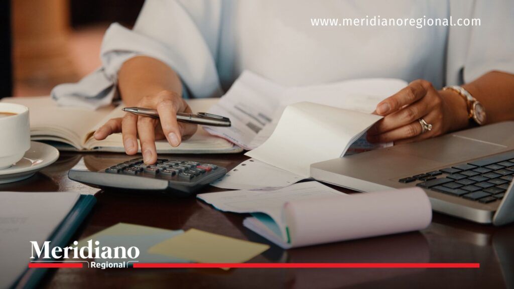 Nuevos impuestos en Colombia impactan a contribuyentes - Meridiano Regional Persona realizando cuentas y revisando facturas como imagen ilustrativa de los nuevos impuestos en Colombia y el impacto del impuesto de renta.