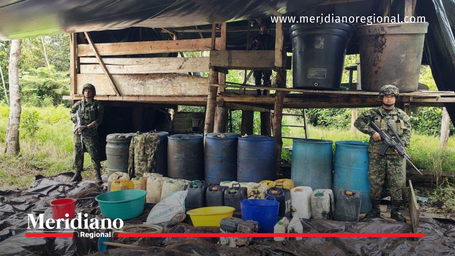 Soldados del Ejército Nacional custodian los insumos incautados tras la ubicación y destrucción de un laboratorio de coca en zona rural de Olaya Herrera, Nariño.