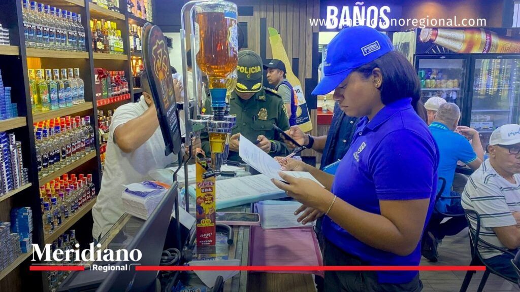 Autoridades verifican cumplimiento del horario de rumba en Cali - Meridiano Regional Funcionario de la Alcaldía de Cali verifica documentos en un bar durante operativo por el horario de rumba en Cali.