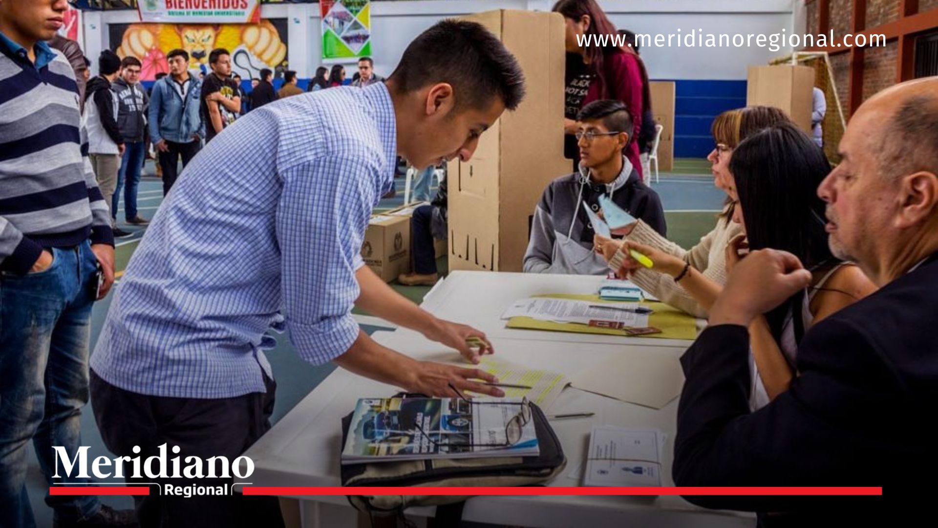 Jurados de votación orientan a los ciudadanos durante el proceso de registro y entrega de tarjetones en una mesa electoral en Colombia.