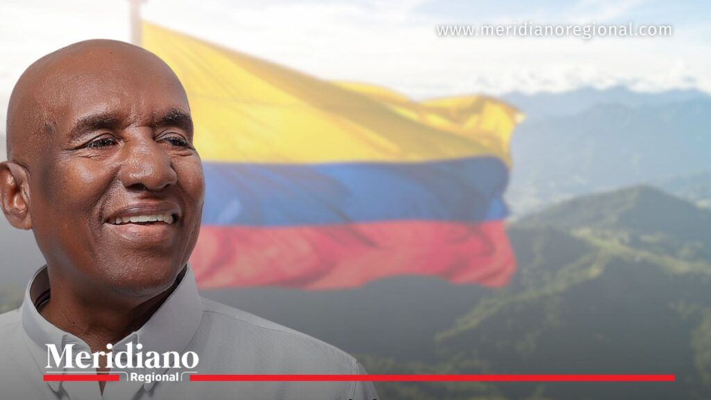 Arnulfo Mostacilla Carabalí con la bandera de Colombia y montañas del Cauca al fondo.