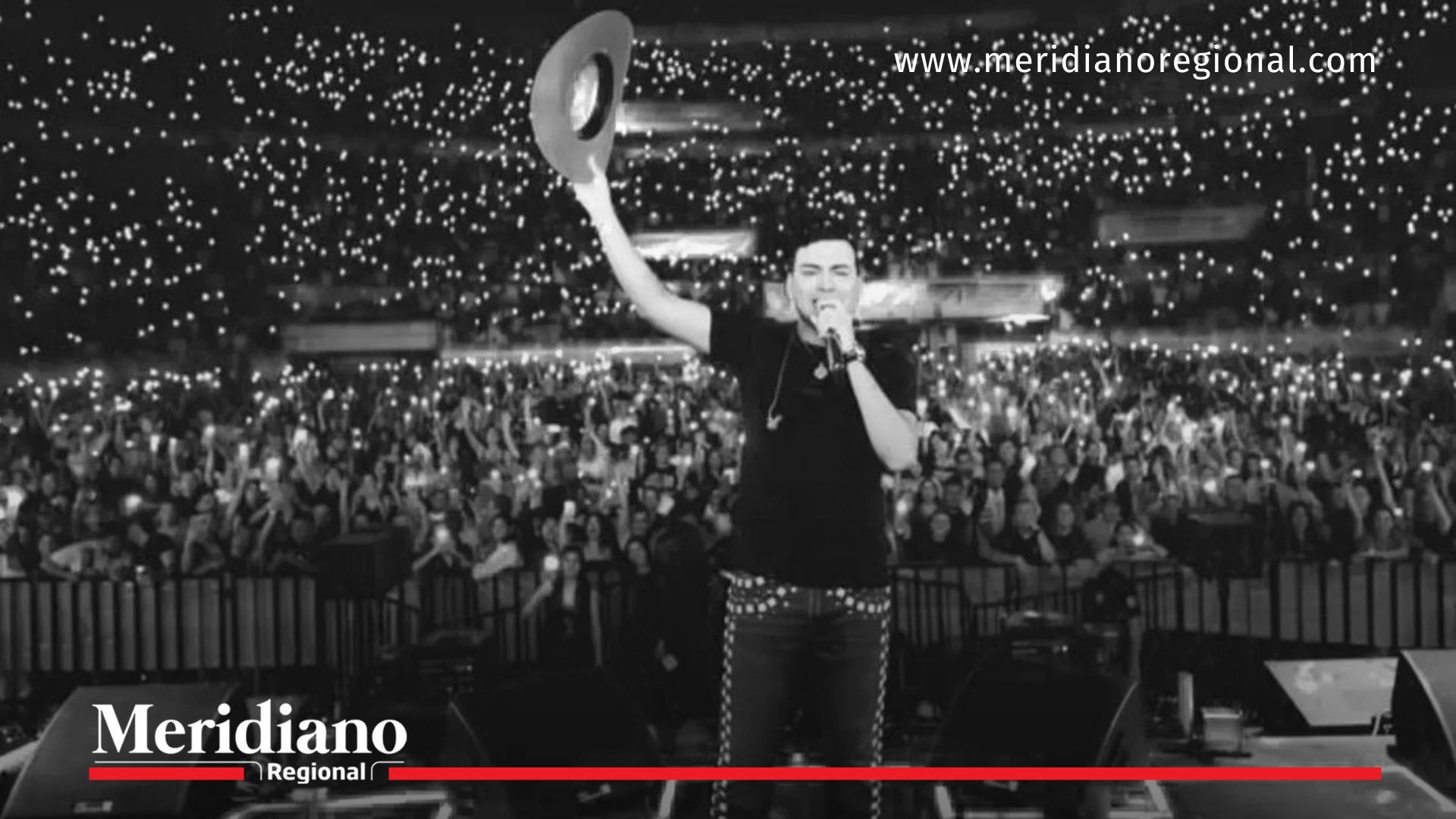 Imagen en blanco y negro de Yeison Jiménez proyectada ante una multitud durante su homenaje en el estadio El Campín, en Bogotá, como representación simbólica de su presencia en el escenario.