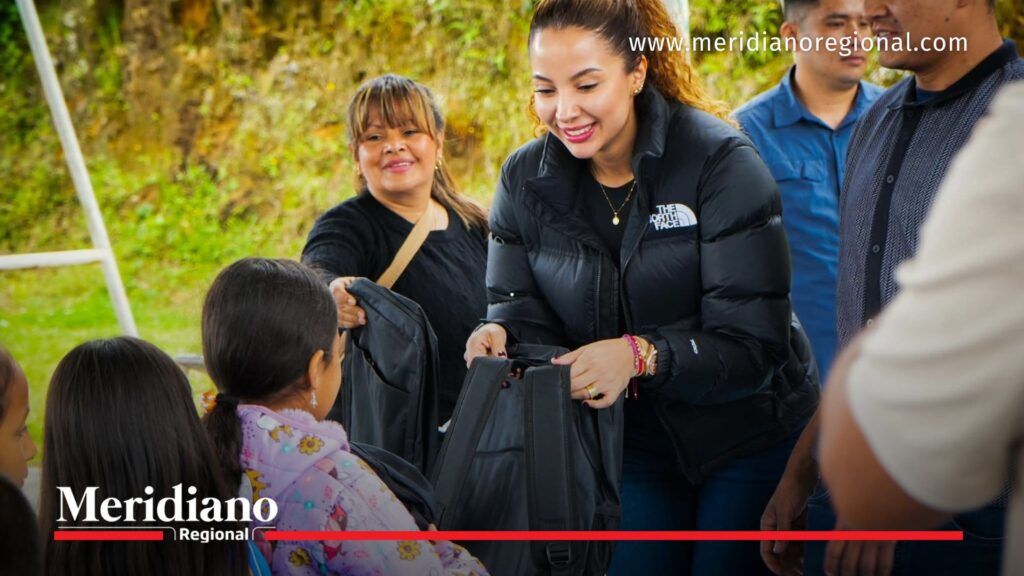 María Victoria Guzmán entrega una mochila escolar a una niña beneficiada por el programa Cafeciendo Sueños en el Cauca.