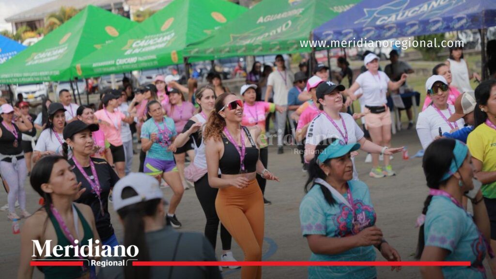 María Victoria Guzmán lidera actividad deportiva en Mujeres en Comunidad - Meridiano Regional María Victoria Guzmán realizando actividad física junto a un grupo de personas en una jornada deportiva al aire libre con carpas al fondo en Popayán.