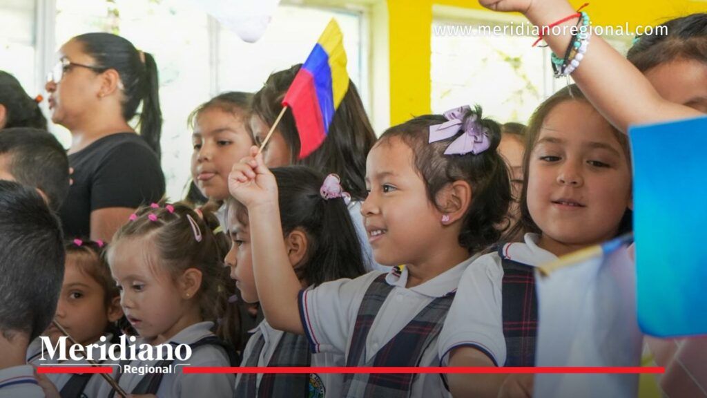 Niñas estudiantes en Argelia Cauca ondeando bandera de Colombia durante entrega de 500 kits escolares por la Gobernación del Cauca en Cafeciendo Sueños.