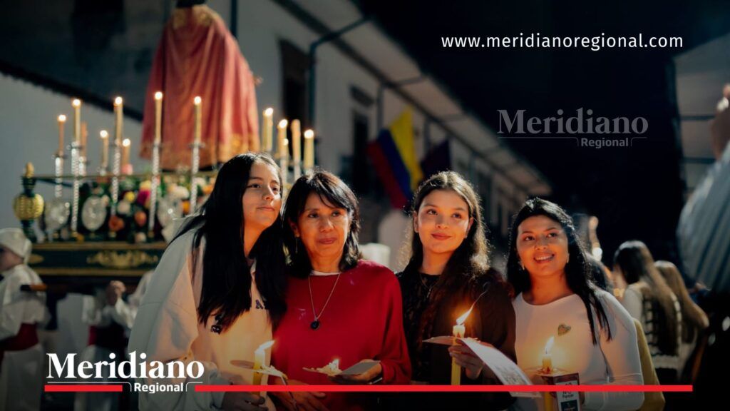 Asistentes viven la Semana Santa en Popayán con fe y tradición - Meridiano Regional Cuatro mujeres sostienen velas durante la procesión de Semana Santa en Popayán, con elementos religiosos al fondo.