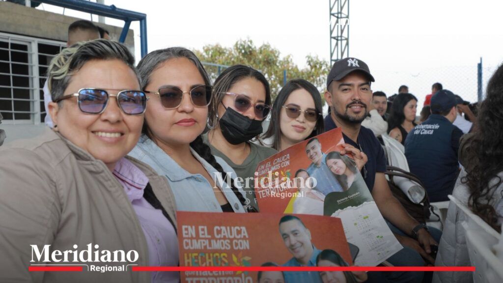 Asistentes sostienen carteles de la Gobernación del Cauca en rendición de cuentas en La Sierra