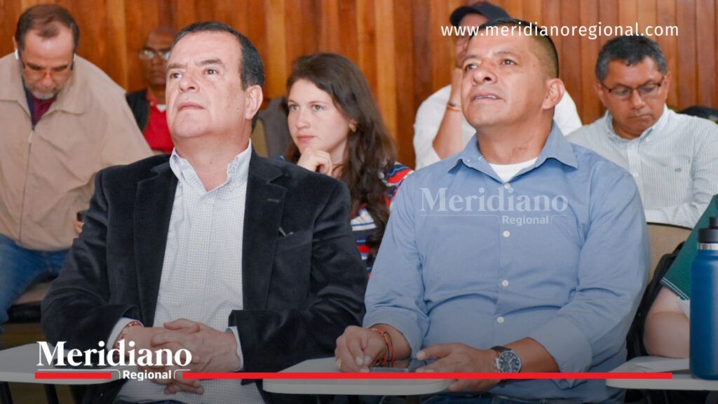 Jhoan Diego Parra Tobar y Jorge Alberto Macías en reunión sobre el proyecto PTAR Popayán junto a otros asistentes en un salón.