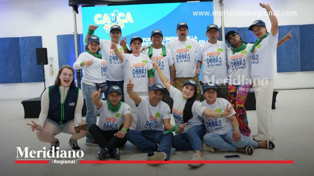 Grupo de docentes del Cauca junto a la líder pedagógica Laura Ríos durante una actividad del programa Cauca Speak English, posando en un espacio académico con material institucional al fondo.