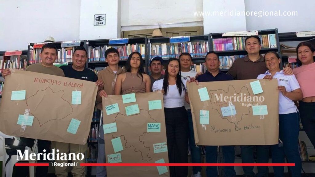 Jóvenes y líderes fortalecen la cultura de paz en Balboa - Meridiano Regional Líderes comunitarios, jóvenes y participantes del taller de cultura de paz en Balboa, Cauca, posan en una biblioteca pública sosteniendo carteles con mapas del municipio y mensajes relacionados con reconciliación, diálogo y convivencia ciudadana.