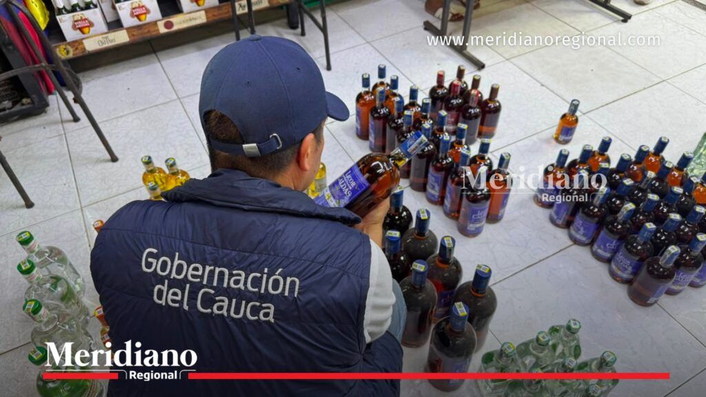 Funcionario de la Gobernación del Cauca inspecciona una botella de licor de contrabando durante un operativo liderado por la Secretaría de Hacienda del Cauca para combatir el comercio ilegal de bebidas alcohólicas.