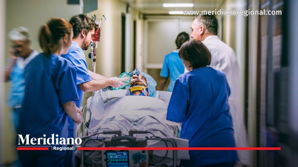 Personal médico traslada a un paciente por un pasillo hospitalario durante una atención de emergencia.