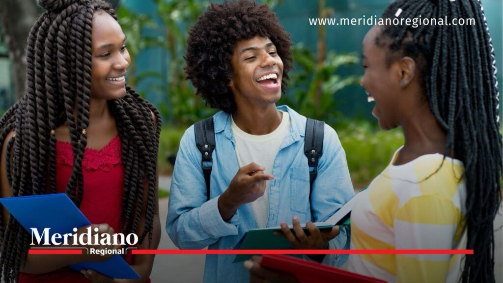 Entornos educativos libres de violencia fortalecen la convivencia y el respeto en el Cauca - Meridiano Regional Tres estudiantes conversan y comparten material académico en un espacio al aire libre, representando la convivencia, la inclusión y los entornos educativos libres de violencia promovidos en las instituciones educativas del Cauca.