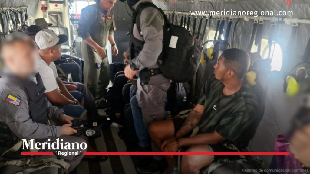 Capturados con fines de extradición son trasladados bajo custodia de las autoridades en una aeronave.