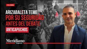 Thumbnail de noticias: hombre de traje sonriente delante de escena de militares; título en rojo sobre seguridad y debate anticapuchos.