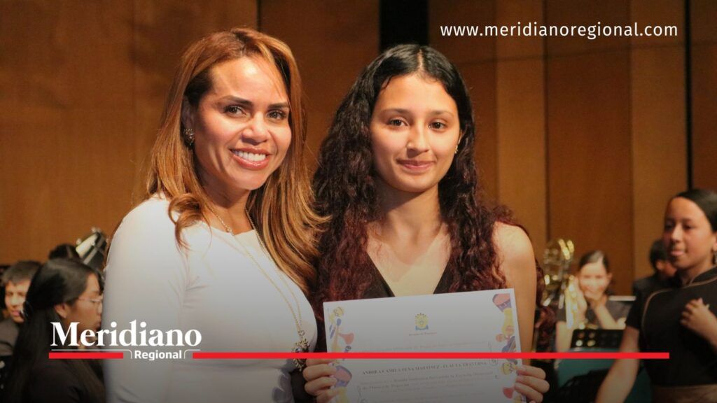 Joven integrante de la Banda Sinfónica de Popayán sostiene un diploma durante un reconocimiento en el Teatro Municipal Guillermo Valencia.