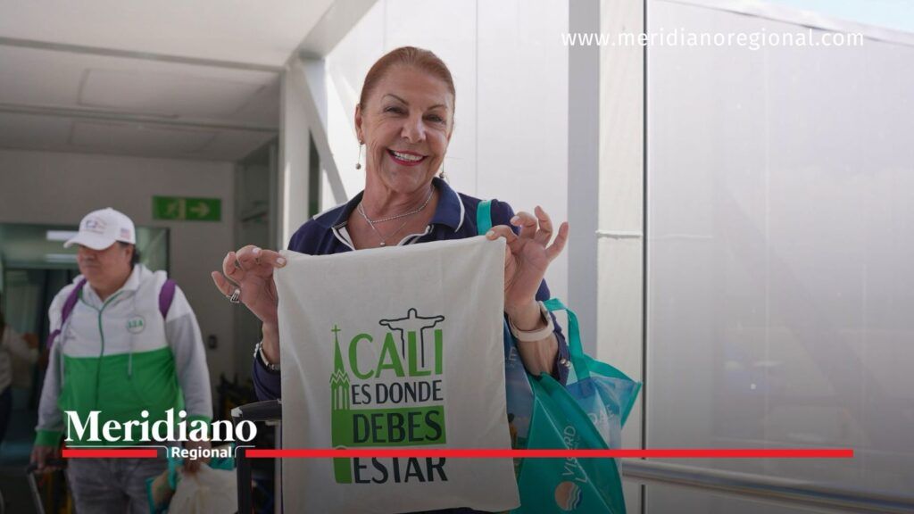 Viajera sostiene una bolsa promocional de Cali con el mensaje «Cali es donde debes estar».