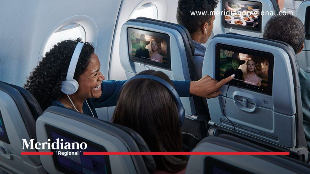 Pasajeros de JetBlue observan pantallas de entretenimiento a bordo de un avión.