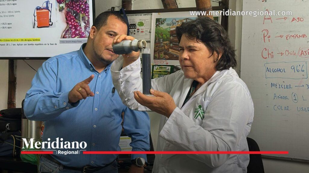 SENA enseña elaboración de biopreparados líquidos en Popayán. - Meridiano Regional Instructora del SENA sostiene un recipiente con líquido oscuro mientras explica su preparación a un participante del curso de agroecología en Popayán.