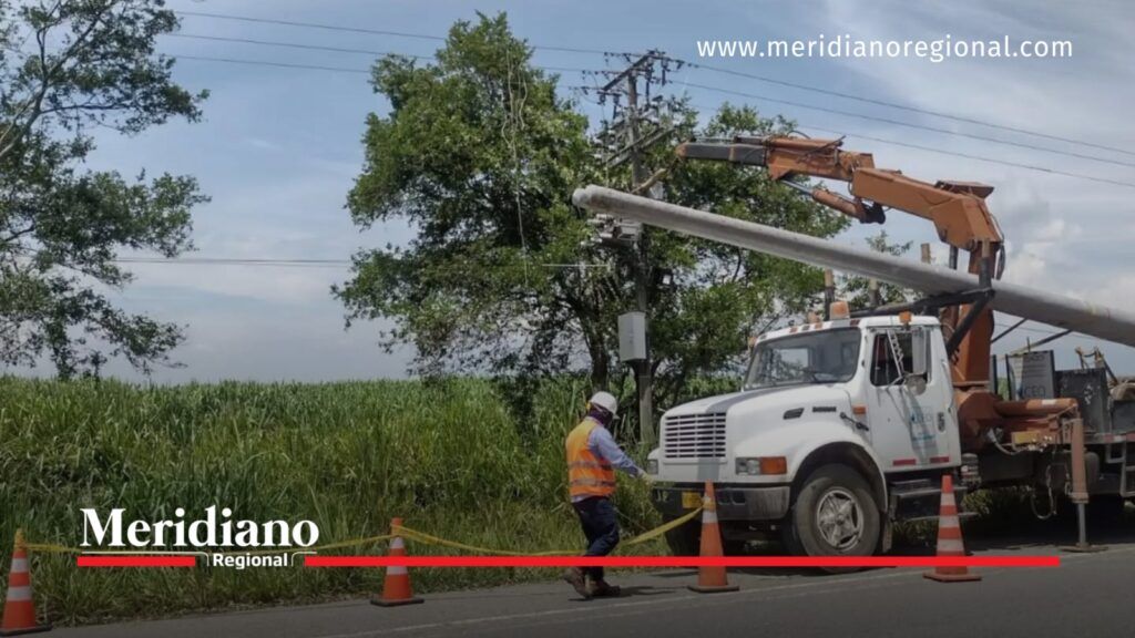 Trabajador de CEO junto a un vehículo con brazo hidráulico durante labores de mantenimiento de redes eléctricas en una zona rural.