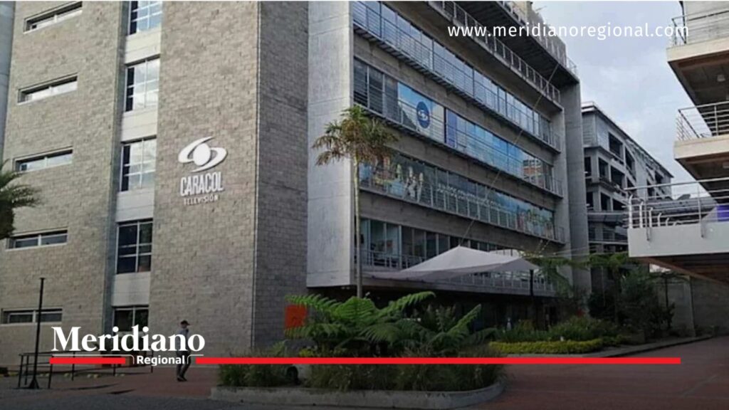 Fachada de las instalaciones de Caracol Televisión, con el logotipo de la empresa sobre un edificio gris de varios pisos, ventanales y zonas verdes en el exterior.