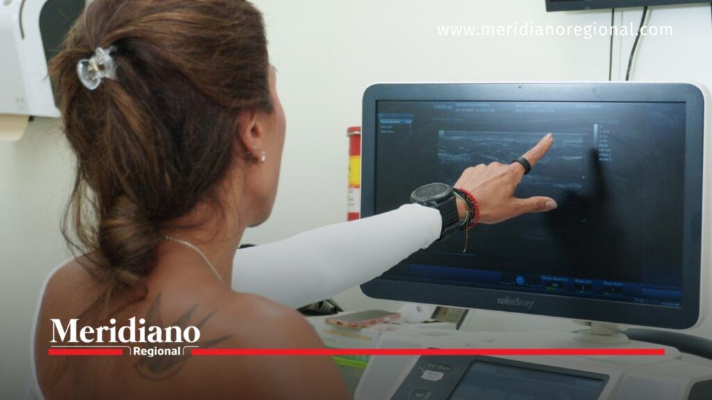 Profesional de salud señala imágenes de una ecografía mamaria en un monitor de diagnóstico en Cali.