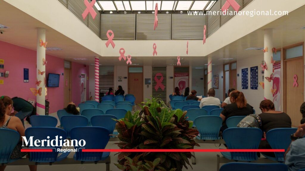 Sala de espera de la IPS Calima en Cali, con pacientes sentados y lazos rosados relacionados con la prevención del cáncer de mama.