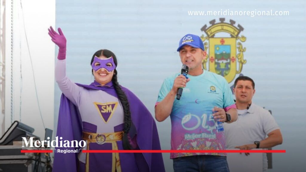 Alcalde Juan Carlos Muñoz Bravo hablando junto a una mujer disfrazada de superheroína durante la celebración del Día de las Mujeres Rurales en Popayán, Cauca.