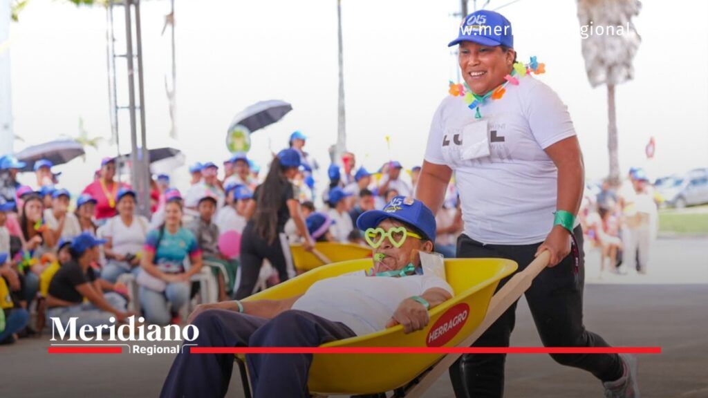 Dos mujeres participan en un juego recreativo con una carretilla amarilla durante la celebración del Día de las Mujeres Rurales en Popayán, Cauca