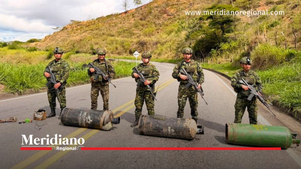 Cinco soldados del Ejército Nacional junto a tres cilindros con explosivos encontrados en la vía Panamericana, en Cauca.