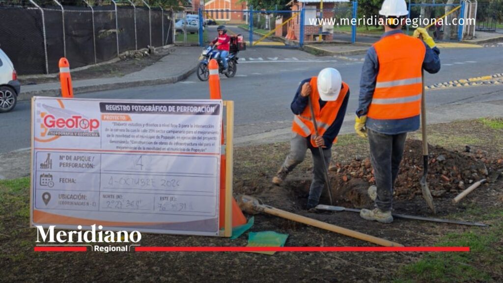 Estudios de suelo para la solución vial en Campanario. - Meridiano Regional Dos trabajadores con chalecos naranjas y cascos blancos realizan exploraciones del suelo junto a una vía en el sector de Campanario, Popayán.