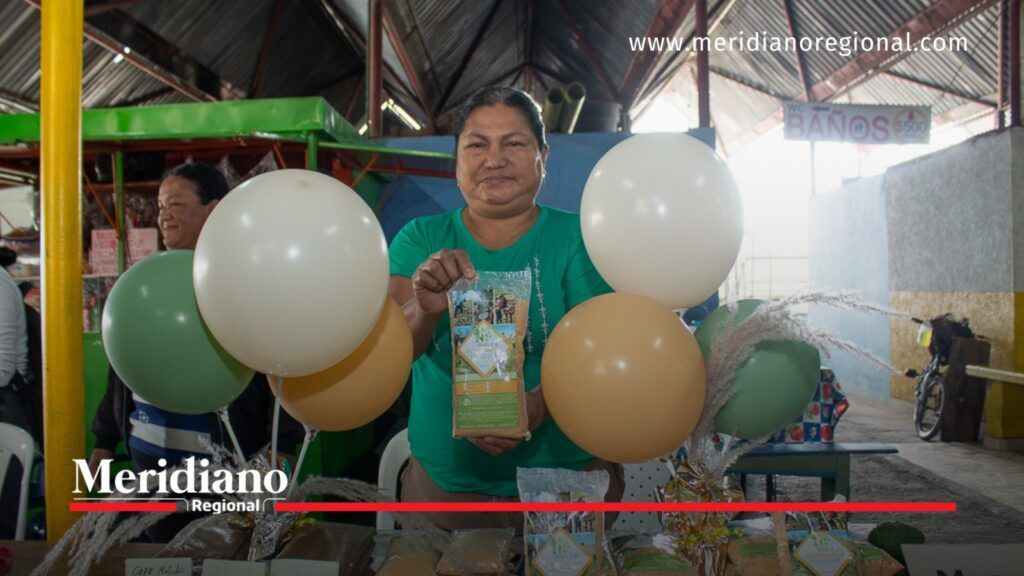 Emprendedora con camiseta verde muestra un producto empacado en la Plaza de Mercado Las Palmas de Popayán.