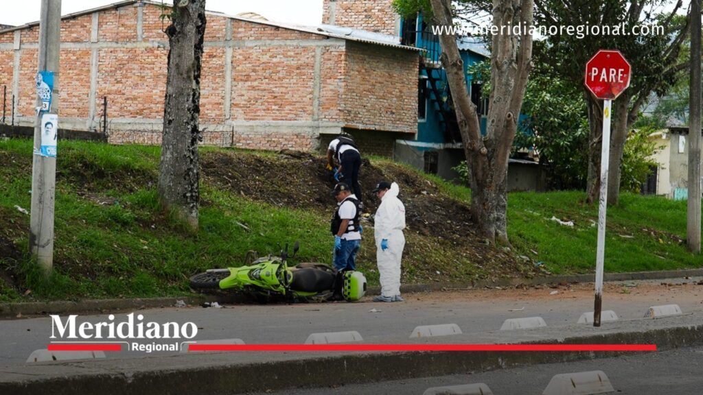 Personal de inspección examina el sector donde permanece una motocicleta policial caída sobre la vía, tras el atentado registrado en Popayán.