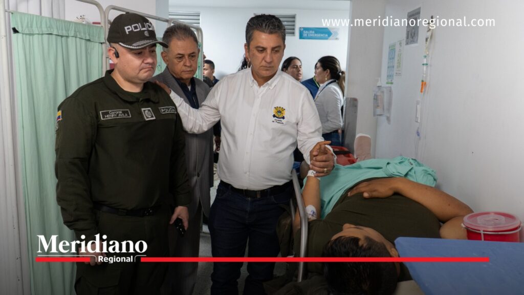 Alcalde Juan Carlos Muñoz Bravo acompaña a policía herido en una camilla hospitalaria, junto a autoridades municipales y policiales.