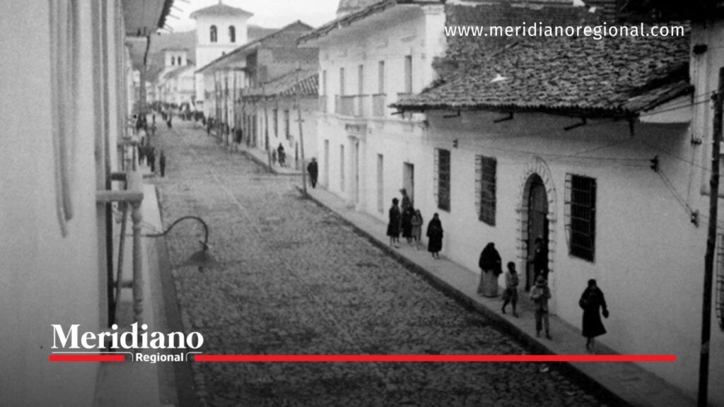 Fotografía de la calle 5 entre carreras 8 y 9 de Popayán hacia 1930, con edificaciones antiguas, vía empedrada y peatones.